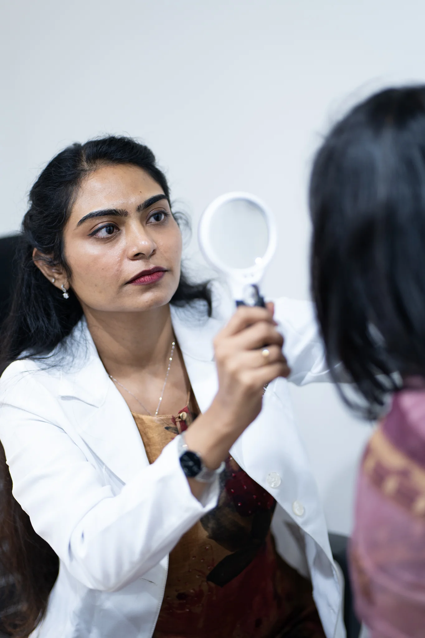 Dermatologist at DermaVue clinic examining a patient for adult acne during a consultation
