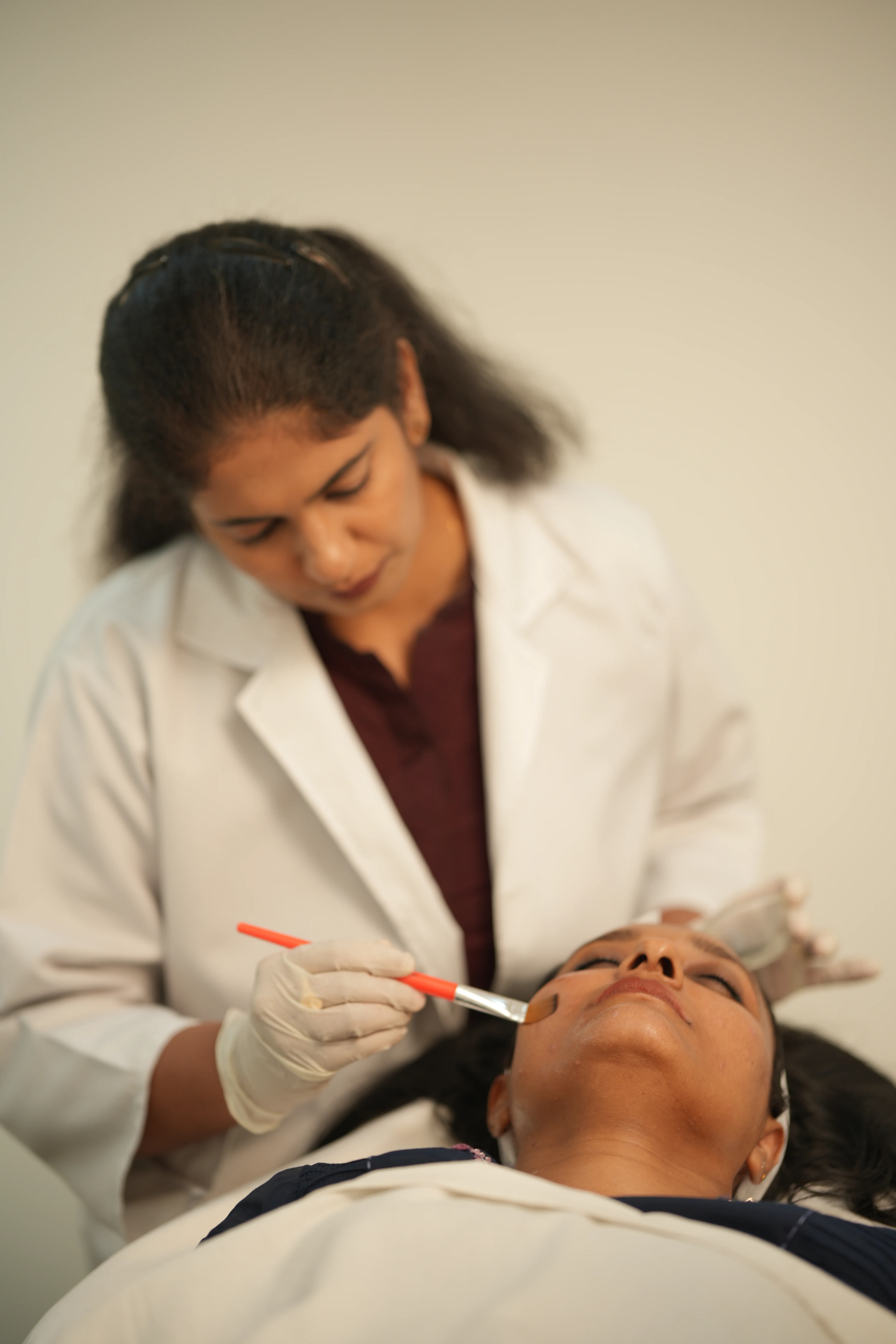 Dermatologist at DermaVue explaining chemical exfoliants to a patient during a skin consultation