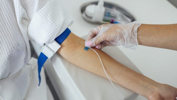 Young brunette woman in a white coat makes medical procedures